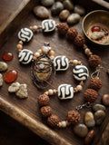 Earthen Roots and Sacred Geometry 23 inch necklace with dzi beads rudraksha and copper wire wrapped fossil coral pendant