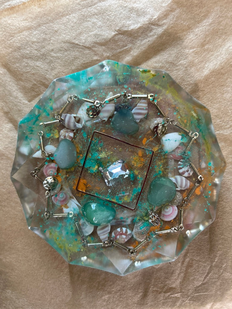 Aquamarine, Seashells & Silver Crown Circle Resin Paperweight – Miniature World with aquamarine stones, spiral seashells and silver bracelet crown in teal clear resin