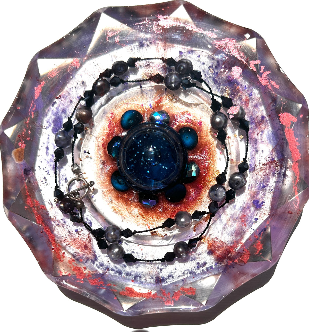 Dark galaxy bead paperweight with navy sphere centerpiece, iridescent crystals, embedded black pearl necklace, and swirling nebula resin