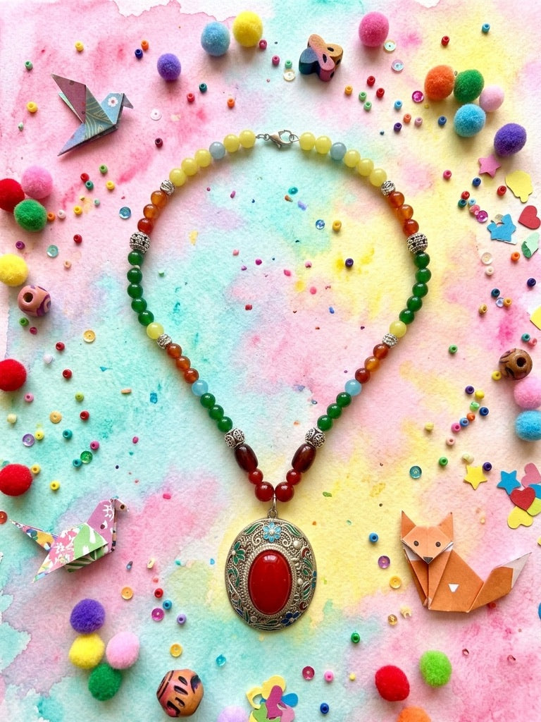 Kaleidoscope Bloom rainbow jade and silver locket necklace on a colourful watercolour background