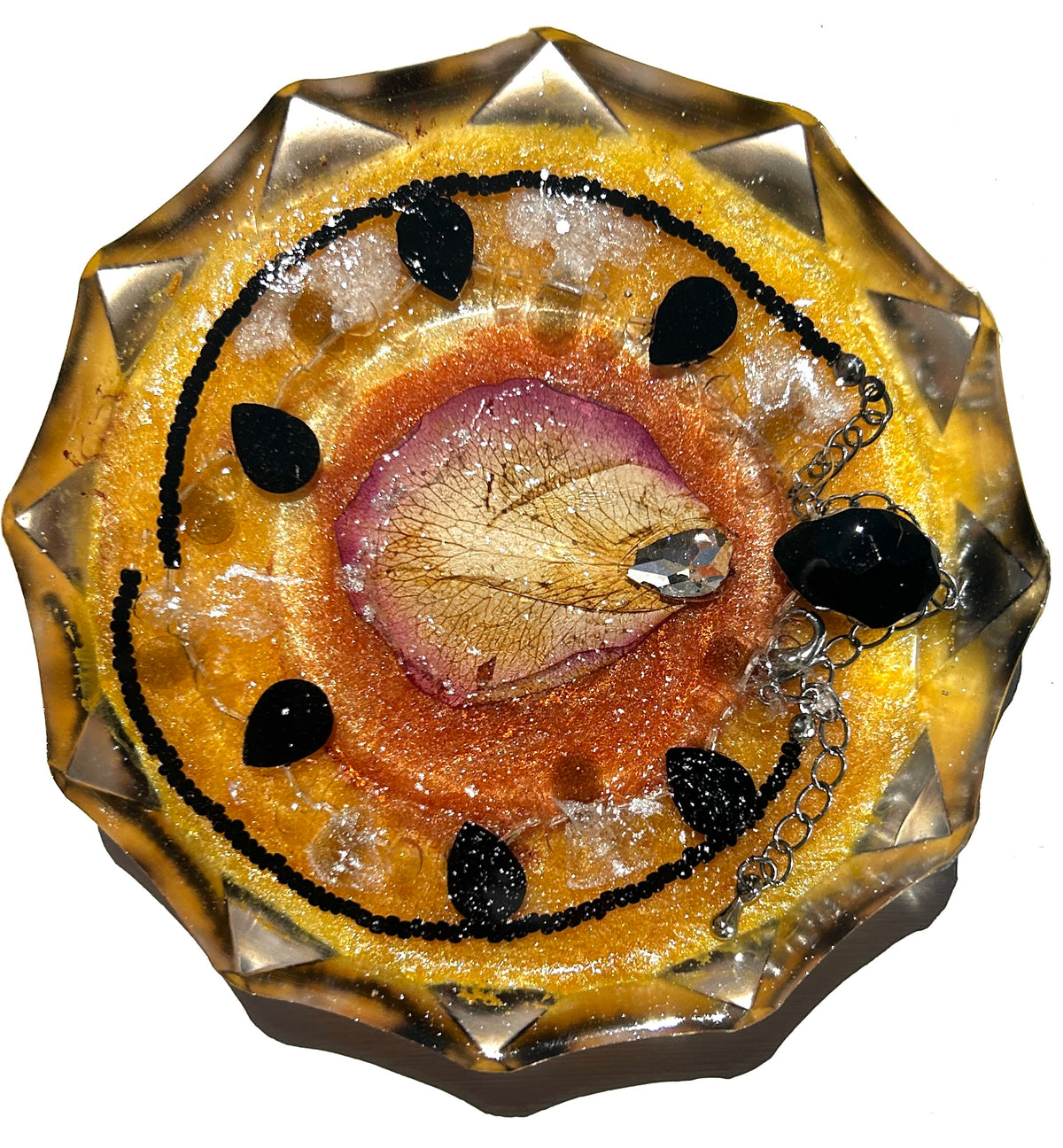 Autumn Alchemy resin paperweight — overhead view of round disc with star-cut faceted edges showing dried skeleton leaf in pink mauve circle with copper bronze resin, crystal teardrop pendant, black obsidian with silver chain and black teardrop stones in golden amber honey resin