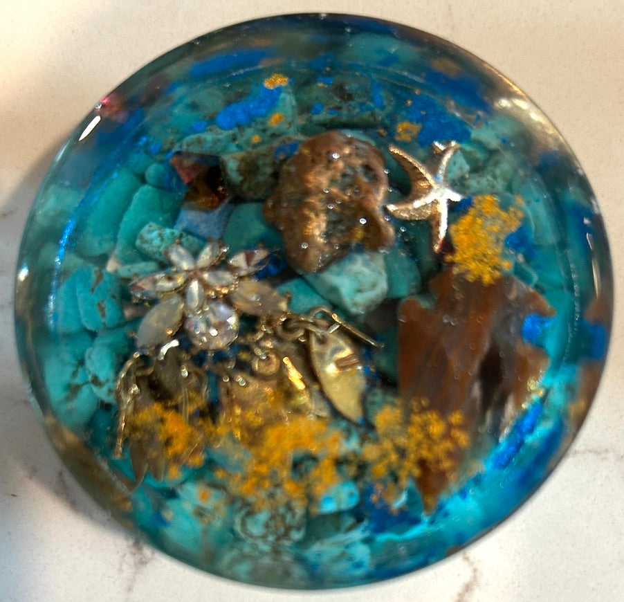 Round ocean resin paperweight with turquoise stones, bronze sea urchin, silver starfish charm, crystal brooch, and cobalt blue swirl