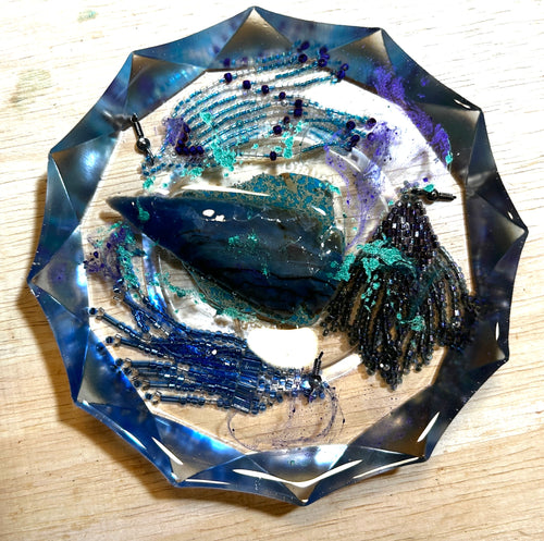 Kyanite Storm resin paperweight — overhead view showing blue kyanite blade crystal, cobalt and gunmetal bead fringe, teal glitter shimmer and purple accents in faceted diamond-edge resin disc