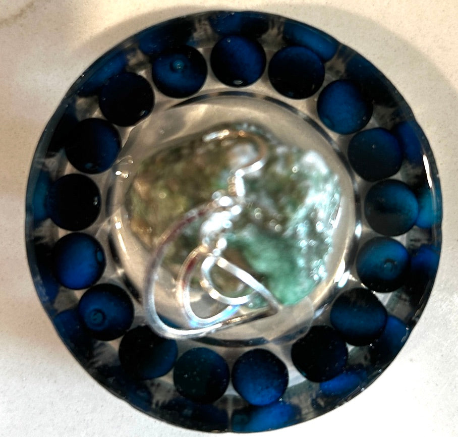 Round resin paperweight with ring of midnight blue lapis beads surrounding a luminous abalone shell center with silver wire swirl