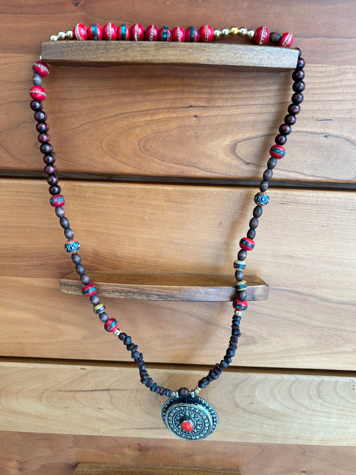 Earth and Ember necklace on wooden rack
