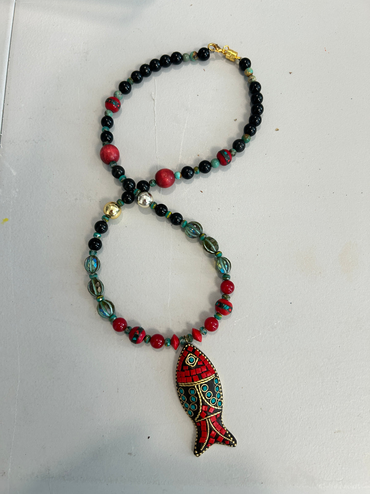 No. 57 Crimson Koi & Onyx necklace on white cushion