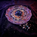 Dark galaxy paperweight styled on midnight black velvet with scattered pearls and cosmic violet lighting