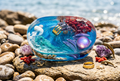 Leaping Porpoise Coral & Violet Stone Oval Resin Paperweight in joyful bright midday ocean editorial scene