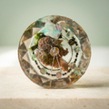 Woodland Luster faceted paperweight with iridescent accents and a silver-toned floral medallion on a light background